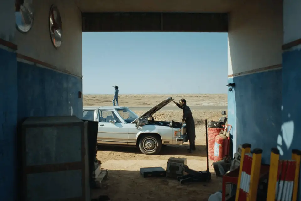 A white vintage car at a remote roadside garage