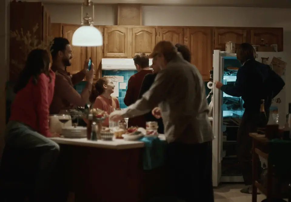 Guests gathering in a warm kitchen during a Christmas party